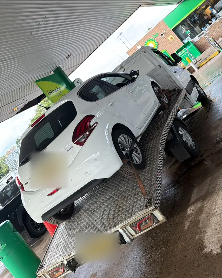 Peugeot 208 at a BP forecourt in the rain