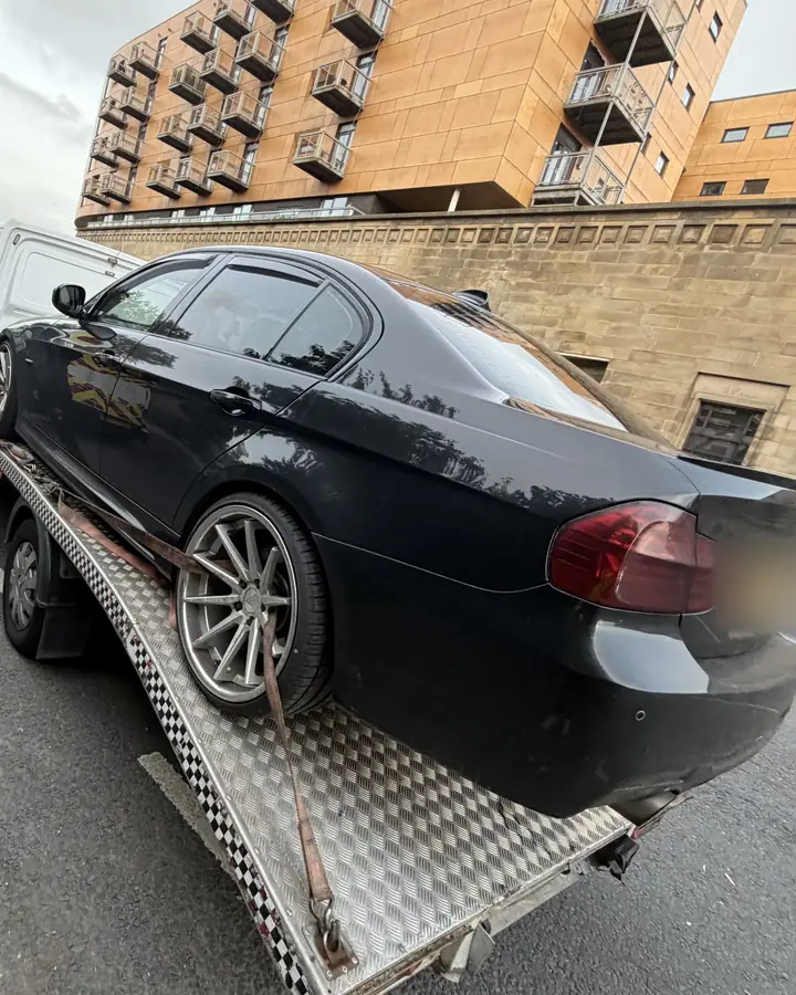 Black BMW 3 Series, loaded on a city street